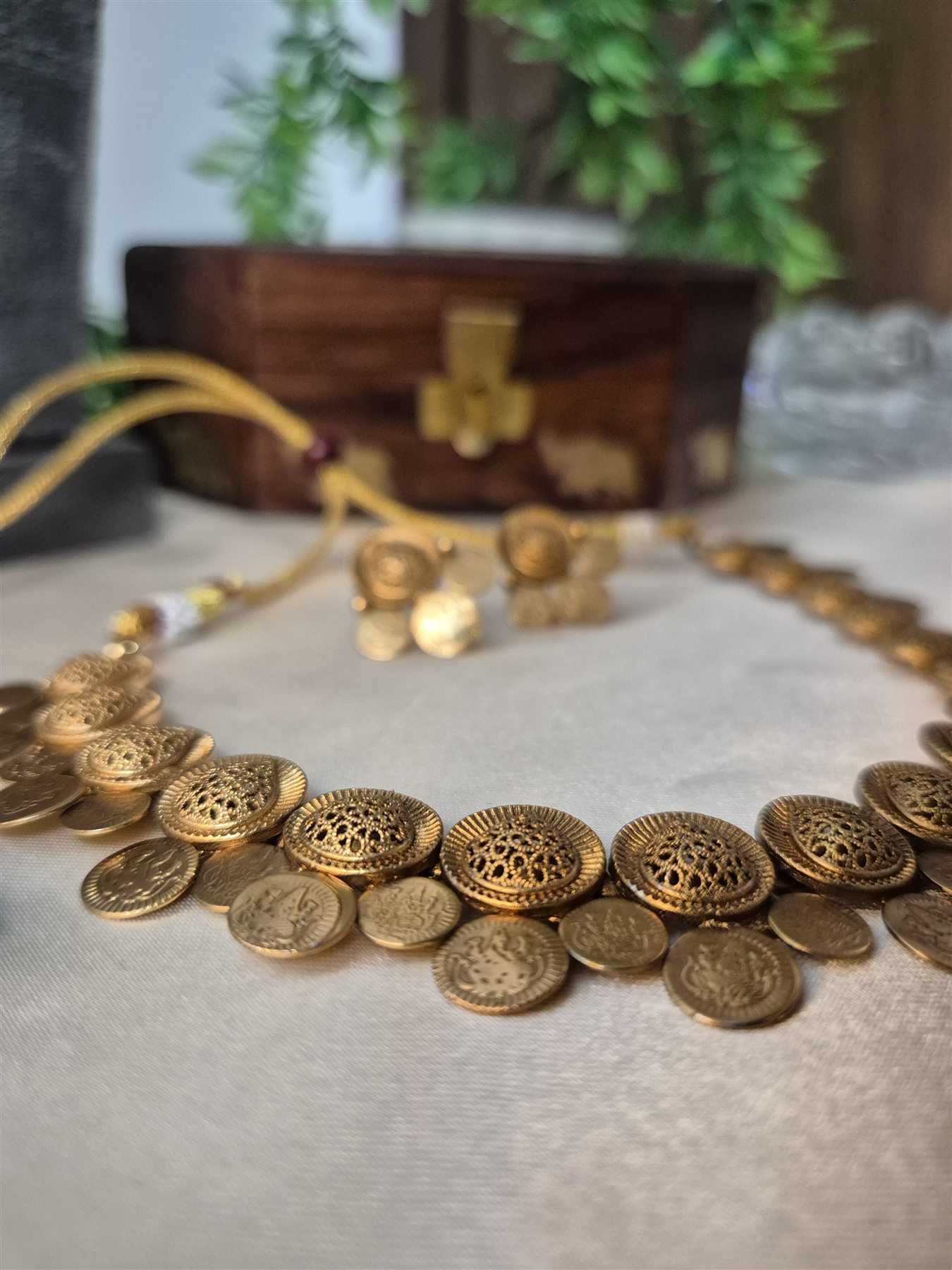 Close-up view of the antique-gold texture on a coin necklace
